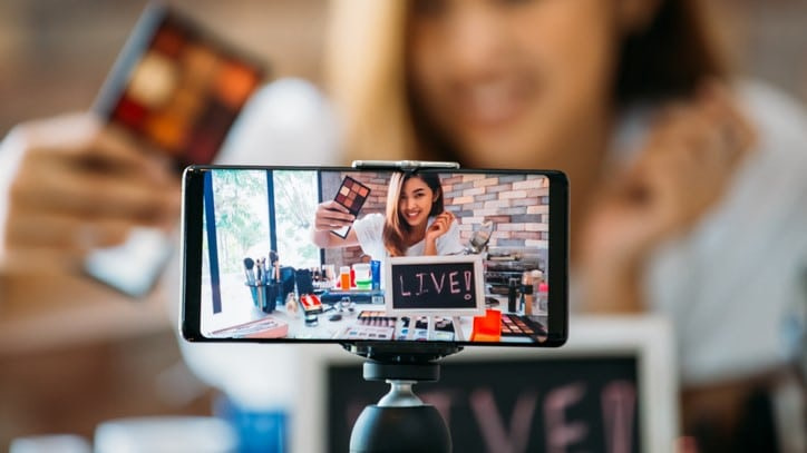 Vlogger filma con uno smartphone live una dimostrazione di cosmetici 